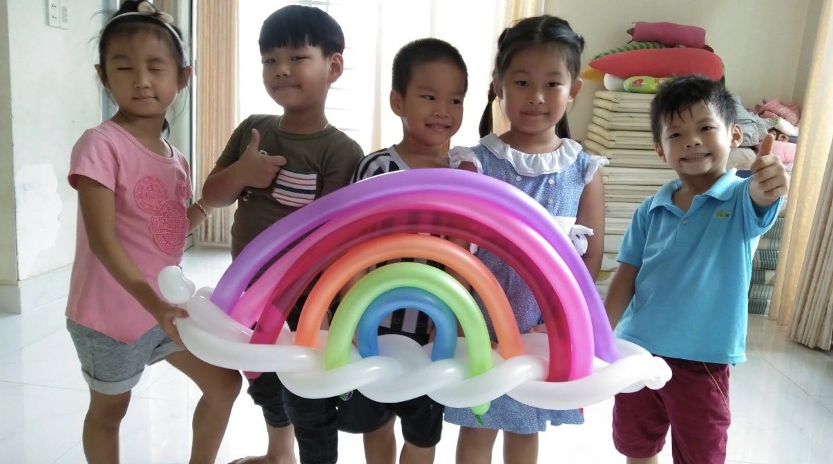 Kids with rainbow balloon sculptures